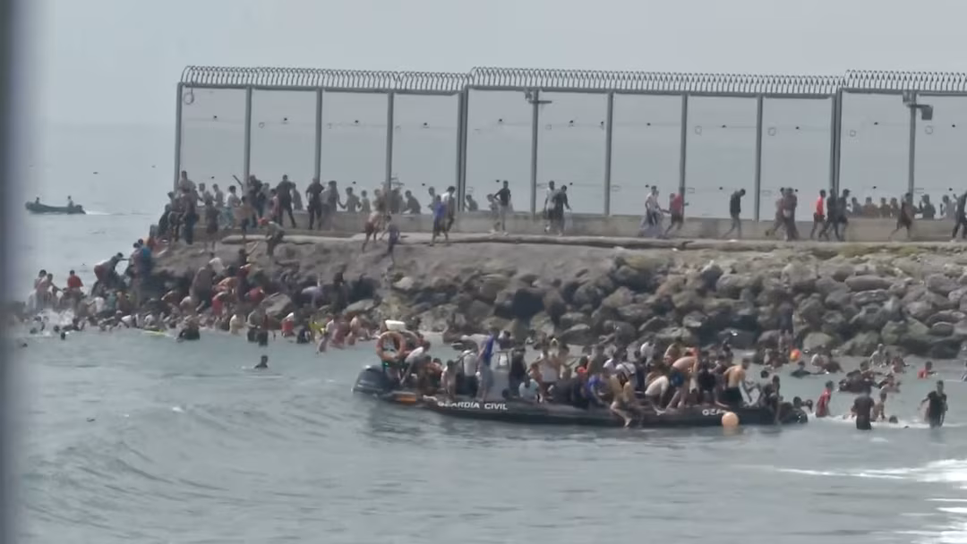 Migrants attempting to enter Spain’s Ceuta enclave from Morocco as security officers reinforce the border