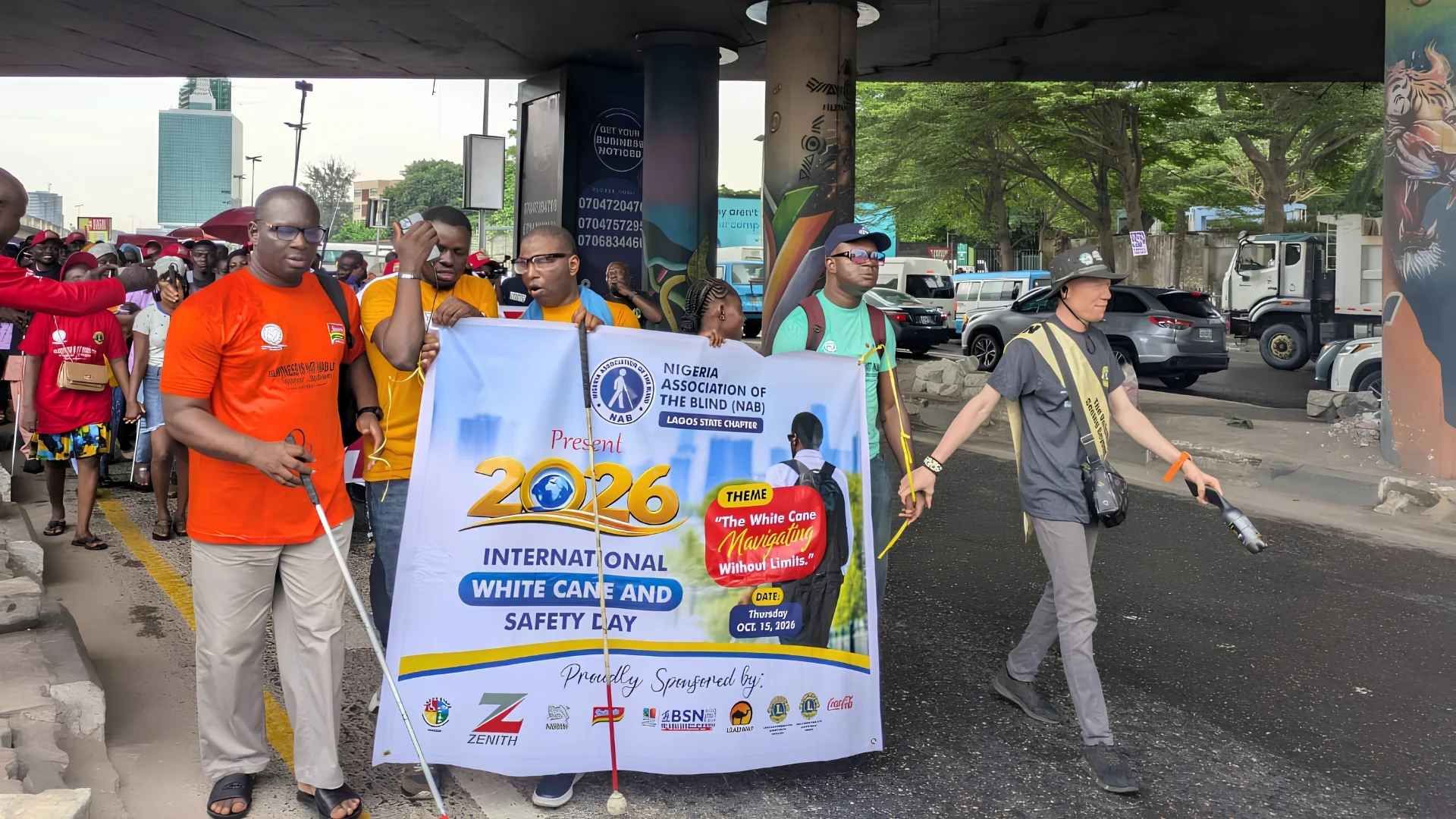 Visually impaired persons and volunteers participate in an awareness walk in Lagos to commemorate International White Cane Safety Day.